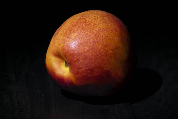 one nectarine green closeup black background