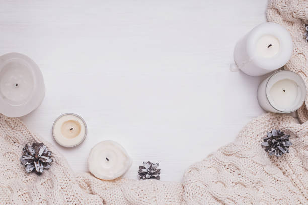 istock Creative winter composition with candles, pine cones and knitted sweater 1187411347