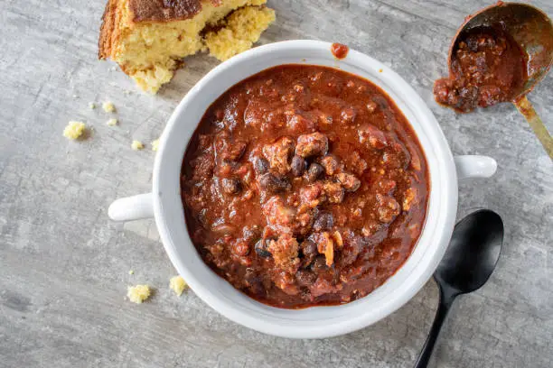 bowl of chili with black beans and cornbread flat lay