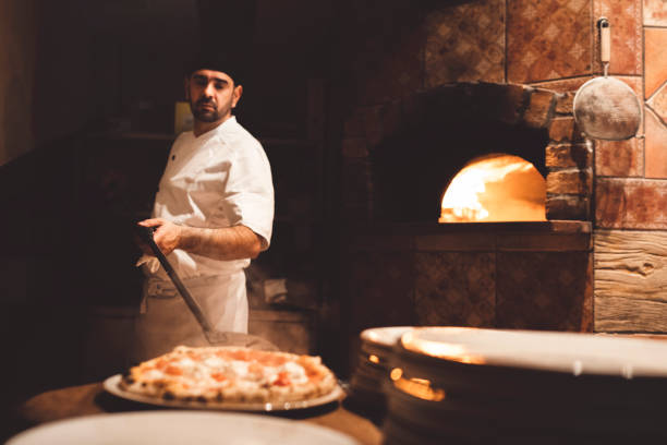istock Pizza maker plating a freshly baked Neapolitan pizza with a peel 1187411951