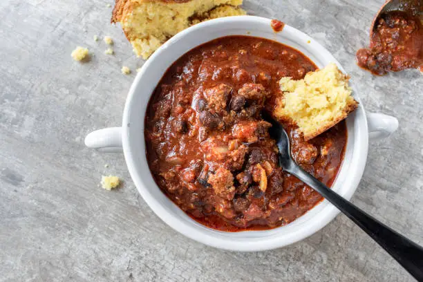 bowl of chili with black beans and cornbread flat lay