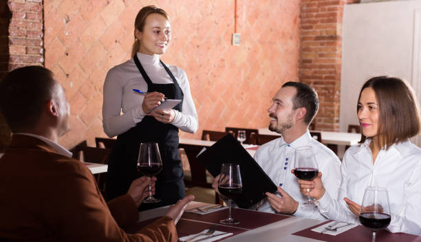 istock Smiling female waiter writing down order 1187412054