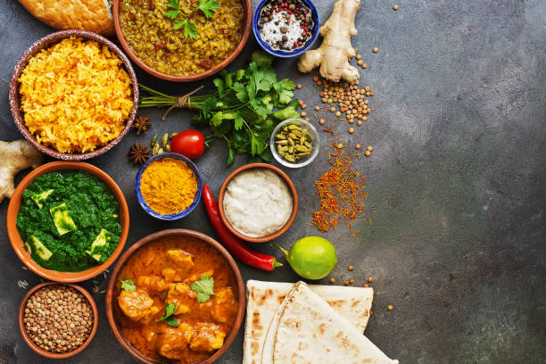 istock Assorted Indian food on a dark rustic background. Set traditional Indian dishes - Chicken tikka masala, palak paneer, saffron rice, lentil soup, pita bread and spices. View from above,copy space. 1187413041
