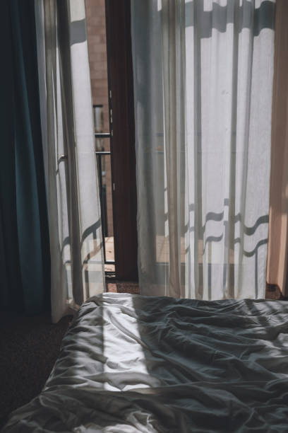 istock Hotel room with bed and white sheets 1187418610
