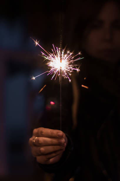istock A woman hand is holding a sparkler at night. 1187419952