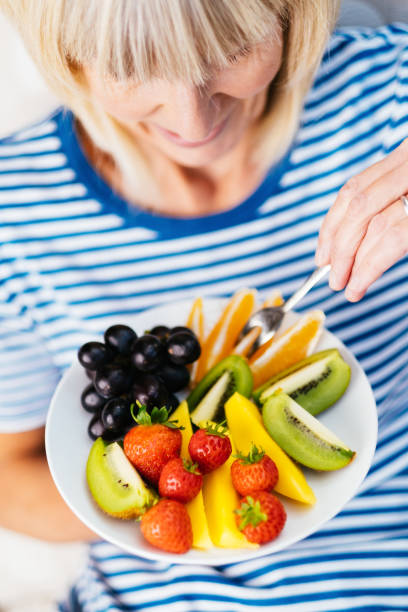 istock Attractive senior woman with fruit lunch 1187421410