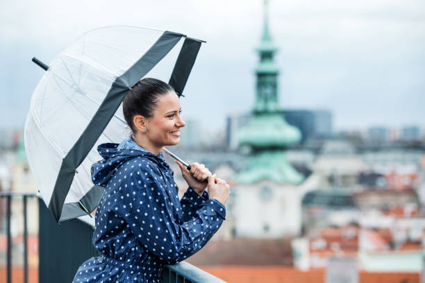 istock A young woman with umbrella standing on a terrace, resting. 1187421526