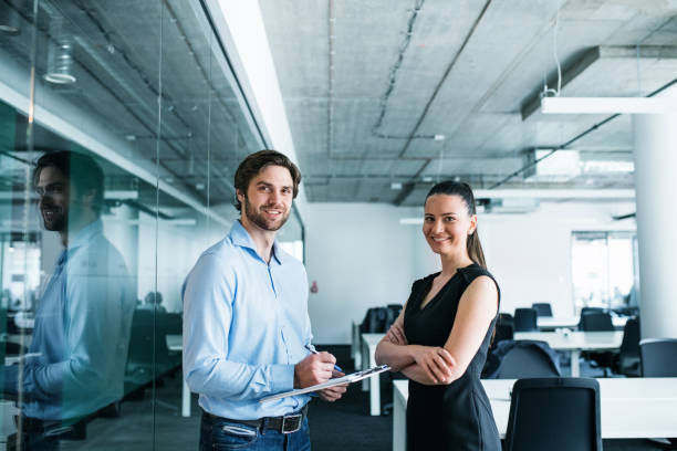 istock Young businesspeople with clipboard in an office, working. 1187421569