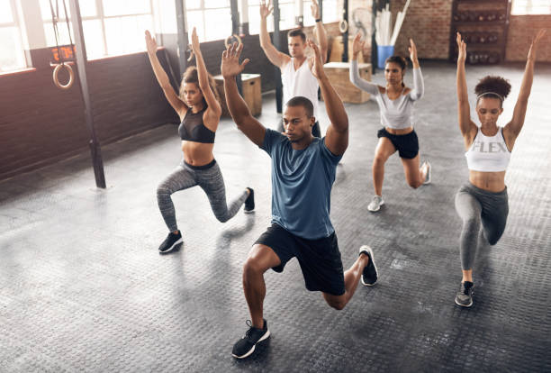 When in doubt gym it out Shot of a group of young people doing lunges together during their workout in a gym exercise class stock pictures, royalty-free photos & images