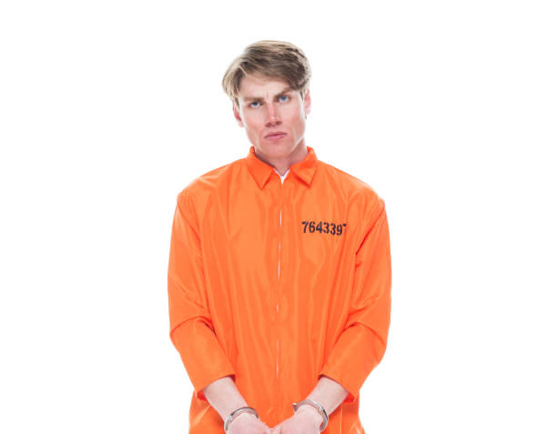 One person / waist up of 20-29 years old adult handsome people caucasian young men / male criminal wearing jumpsuit / uniform who is serious / confidence / concentration and using handcuffs / crime One person / waist up of 20-29 years old adult handsome people caucasian young men / male criminal wearing jumpsuit / uniform who is serious / confidence / concentration and using handcuffs / crime jumpsuit stock pictures, royalty-free photos & images