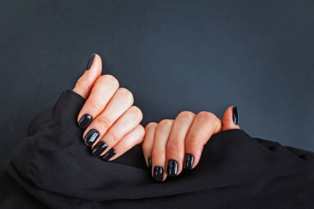 istock Womas hands demonstrating salon manicure with black nailpolish 1187423639