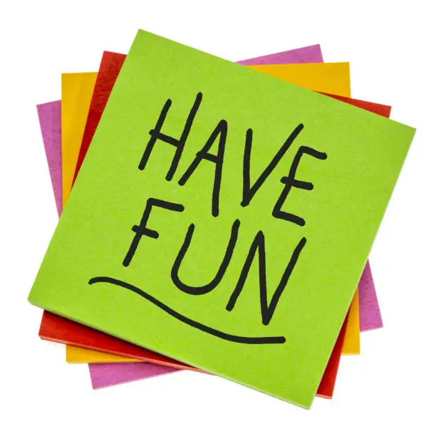 have fun reminder - motivational slogan or wish handwritten on an isolated sticky note