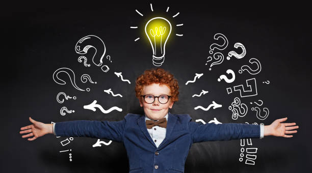 istock Little student child embracing on blackboard background with lightbulb 1187424036