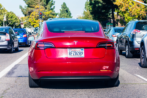 August 5, 2019 Mountain View / CA / USA - Rear view of red Tesla Model 3 driving on a street in Silicon Valley