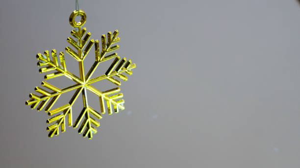 istock One golden plastic snowflake decoration on a gray background 1187427971