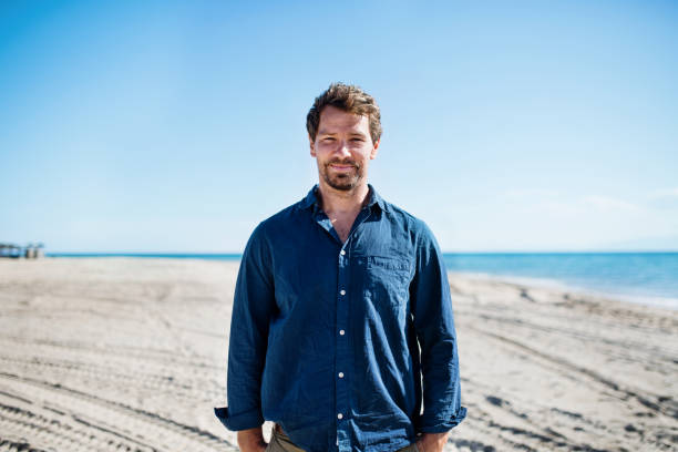 istock Front view of mature man on a walk outdoors on beach. 1187429180