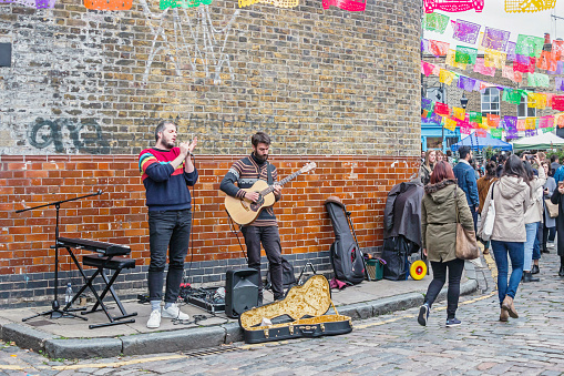 London, UK -  November 03, 2019: Street artist performance with guitar at Columbia Road Flower Market in London