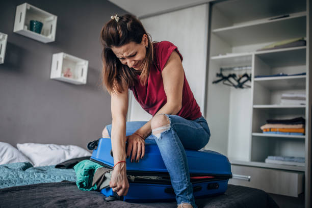 istock Woman is struggling to suitcase 1187445096
