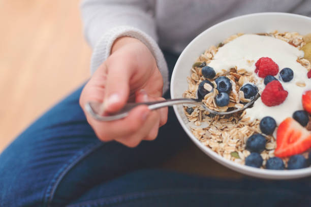 mujer comer tazón de desayuno saludable. - cereal breakfast granola healthy eating fotografías e imágenes de stock