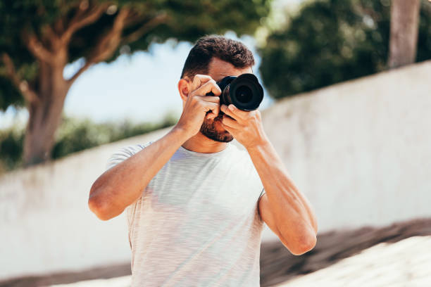 istock Young man with DSLR camera in city 1187453204