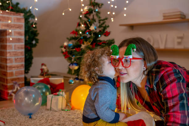 istock Pretty little boy in sweater stands with a toy before a Christmas tree 1187454819