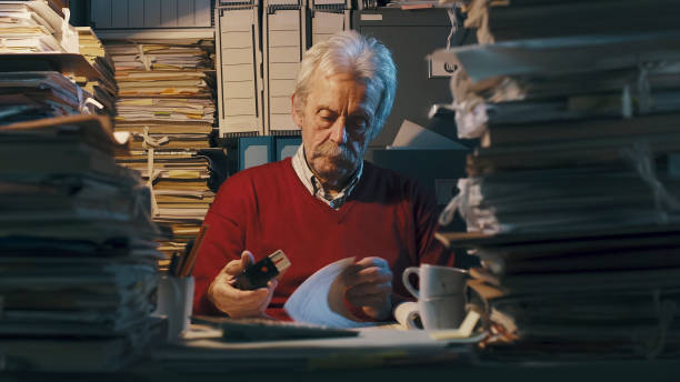 istock Senior clerk overloaded with paperwork 1187461235