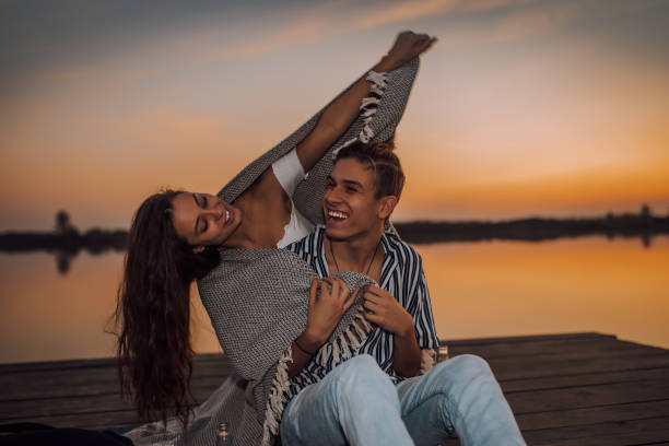 istock Young couple enjoying in a romantic date by the river, covered with blanket 1187463789