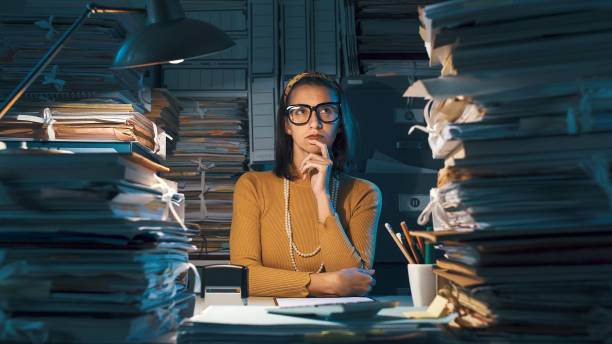 istock Pensive young office worker with hand on chin 1187468539