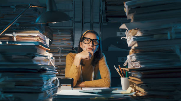 istock Pensive young office worker with hand on chin 1187468977