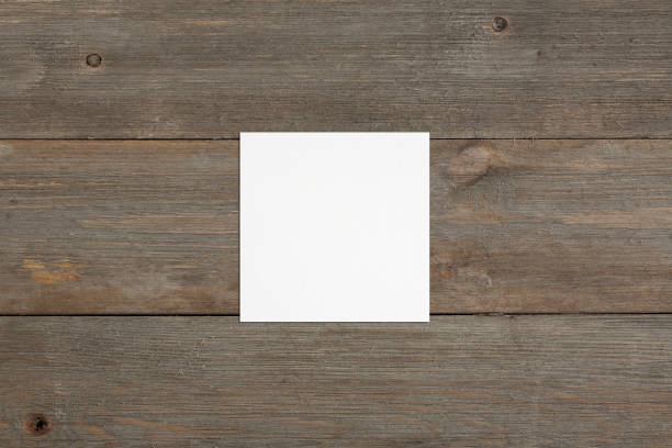 istock Square empty white business card mockup on wooden background. 1187469827