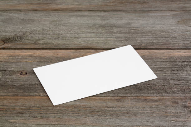 istock Standard empty white business card mockup on wooden background. 1187469942