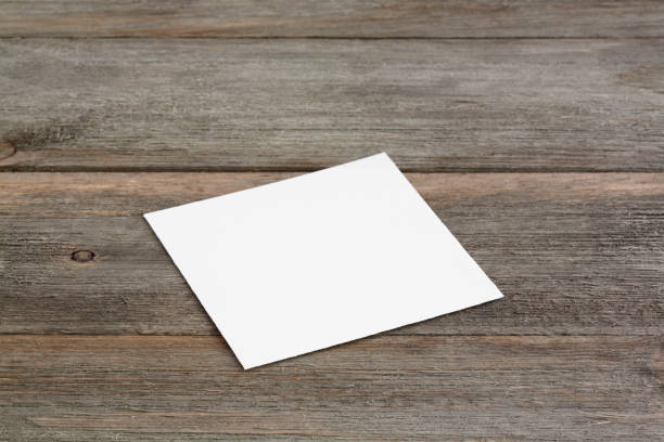 istock Square empty white business card mockup on wooden background. 1187469955