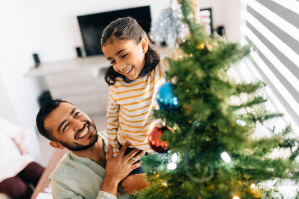istock Father and Daughter Decorating Christmas Tree 1187476582