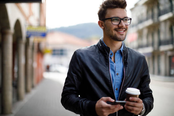 istock Smiling young man drinking coffee outdoor 1187477187