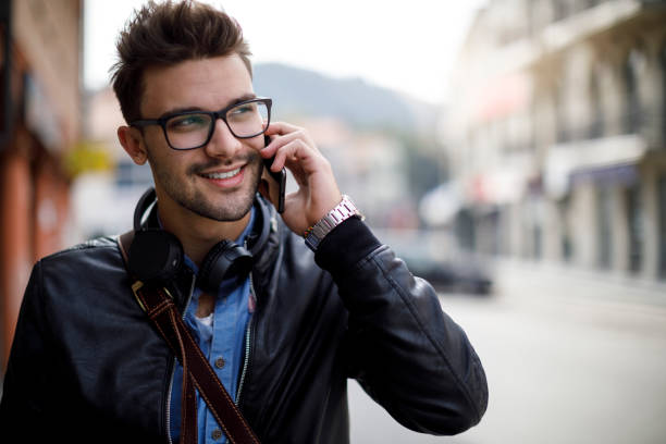 istock Smiling young man using mobile phone outdoor 1187477389