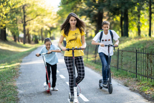 istock Three friends riding scooters in park, enjoying vacations 1187482453