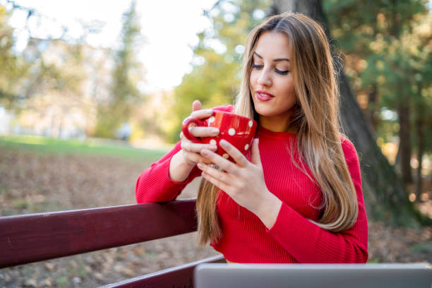 istock Working outdoor sitting on a park bench in fall season 1187483086