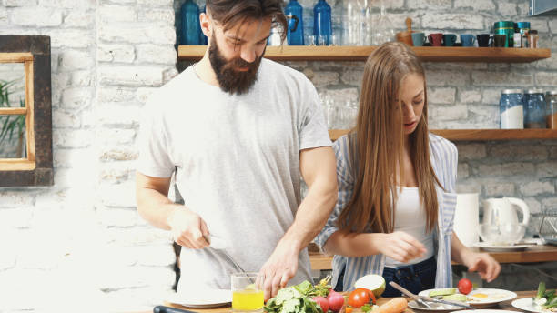 istock Young couple making dinner together at home 1187483267