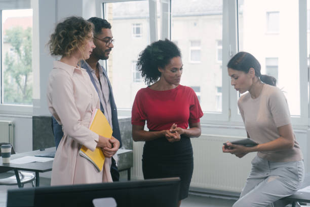 istock Businesspeople in office with woman using digital tablet 1187487193