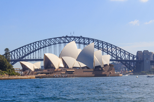 Sydney, Australia - March 24th 2013: View of the Opera House in Sydney Harbor. The Sydney Harbour Bridge is in the background.