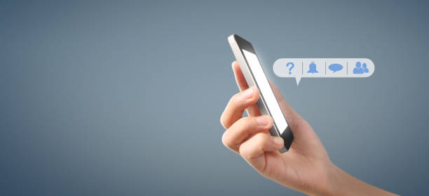 istock Man hand holding smartphone device and touching screen 1187501739