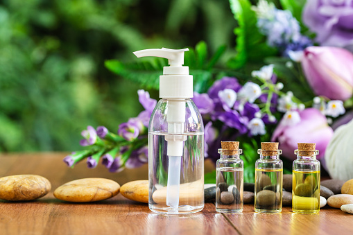 Bottle essential oil for spa massage with flower background