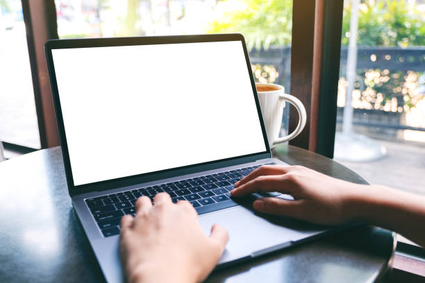 istock a woman using and typing on laptop with blank white desktop screen with coffee cup on the table 1187520486