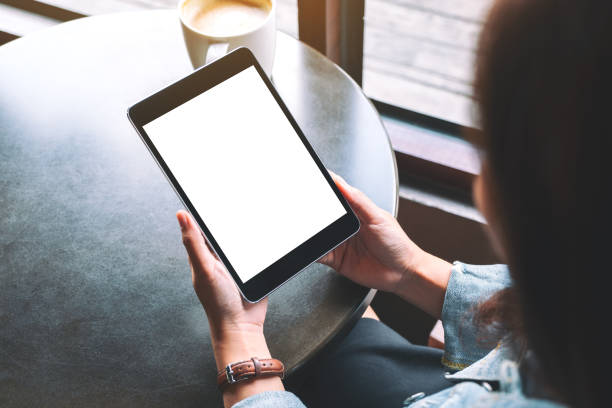 istock a woman holding black tablet with white blank screen and coffee cup on the table 1187521018