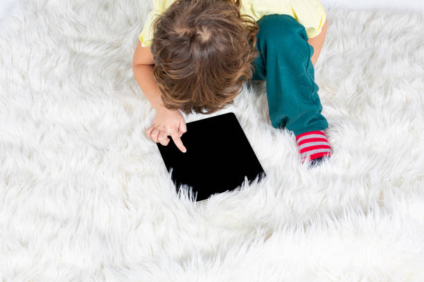 istock Little Boy working tablet on carpet 1187523560