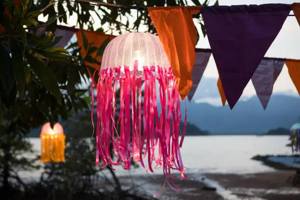 Photo of Festive multicolored flags decoration on the beach in the tropics on the background of the sea