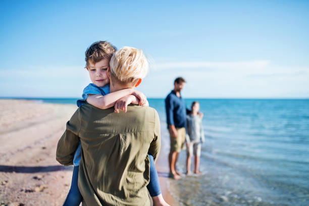 istock Young family with two small children walking outdoors on beach. 1187535689