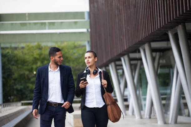 istock Co-workers with checking the cell phone in the street 1187539831