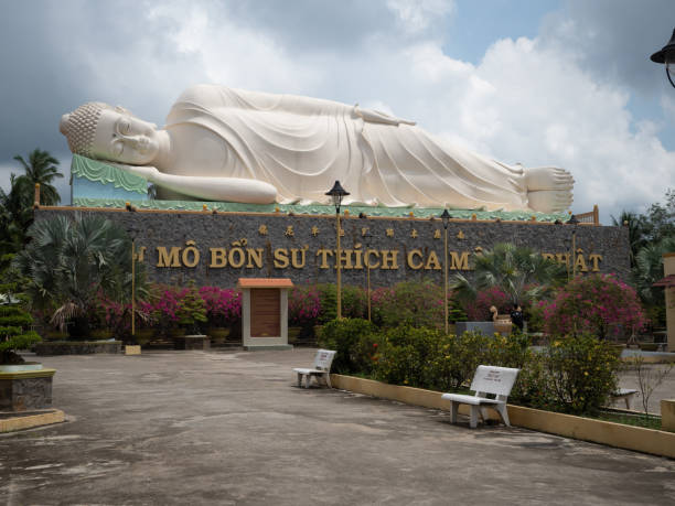 Giant Reclining Buddha Near My Tho in Vietnam Giant reclining Buddha in Vinh Trang Chua temple near My Tho in Southern Vietnam's Mekong Delta. laughing buddha garden statue stock pictures, royalty-free photos & images