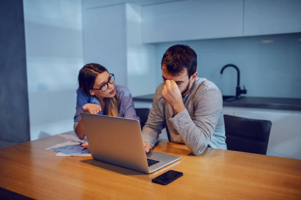 istock Young attractive caucasian couple arguing about wasting their savings on unnecessary things. They don't have enough money on account to pay bills. 1187551363